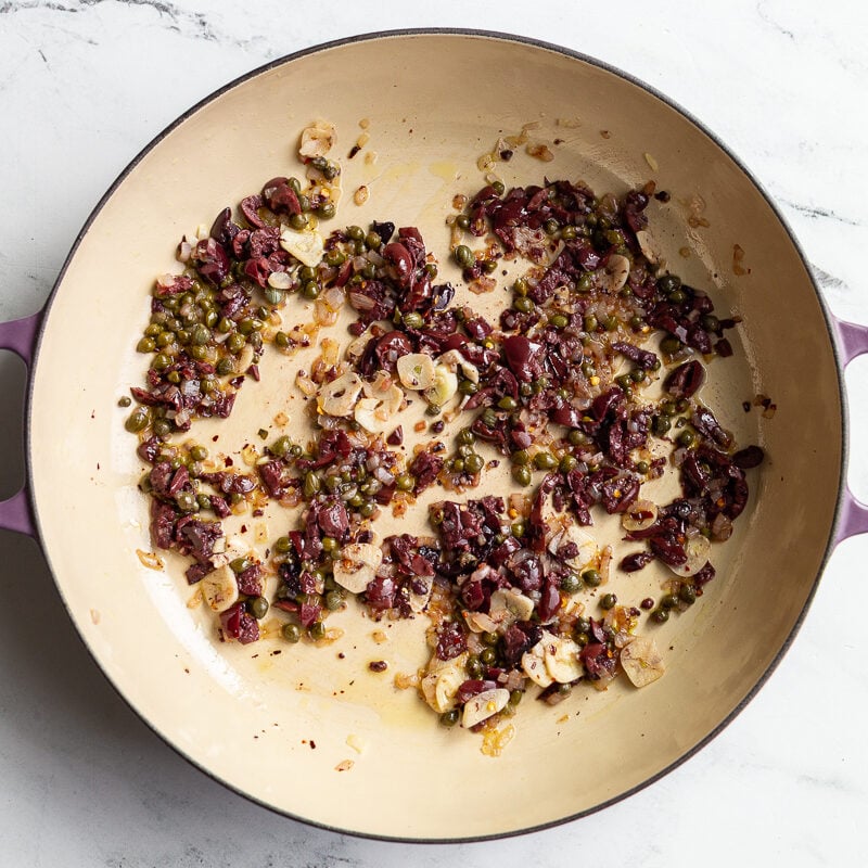 olives and capers sauteed in a skillet