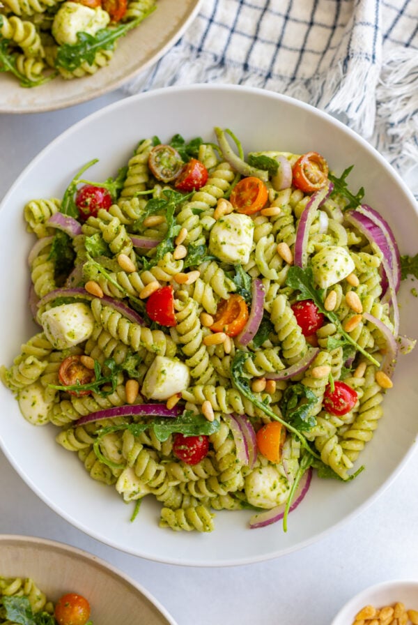 Easy Pesto Pasta Salad in a large bowl with a napkin in the corner of the shot