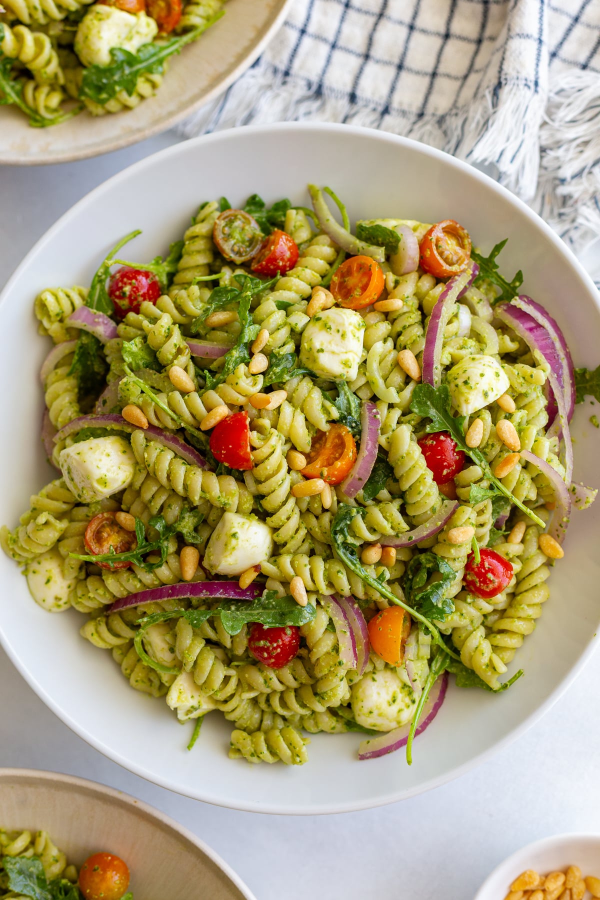 Easy Pesto Pasta Salad in a large bowl with a napkin in the corner of the shot