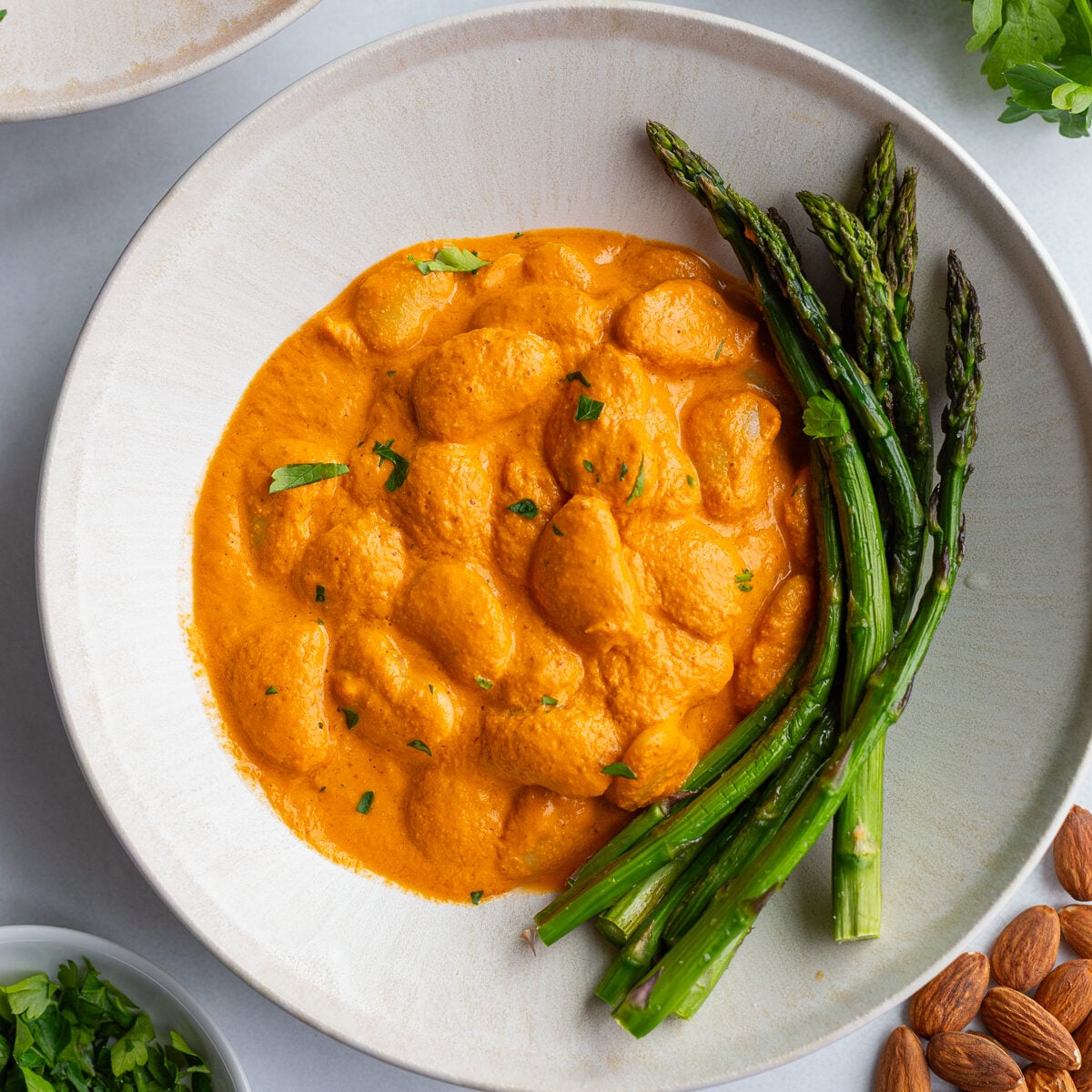 romesco butterbeans in a bowl with asparagus