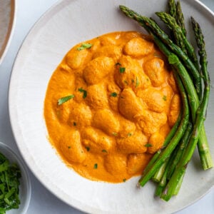 romesco butterbeans in a bowl with asparagus