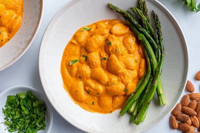 romesco butterbeans in a bowl with asparagus