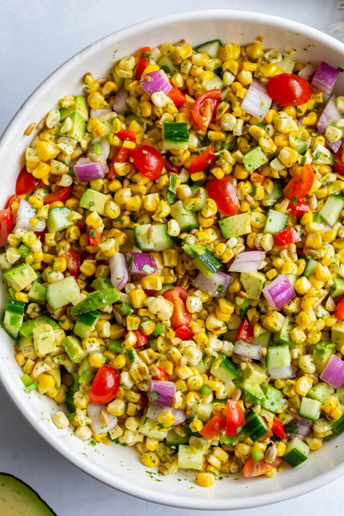 grilled corn salad with fresh veggies in a large white bowl