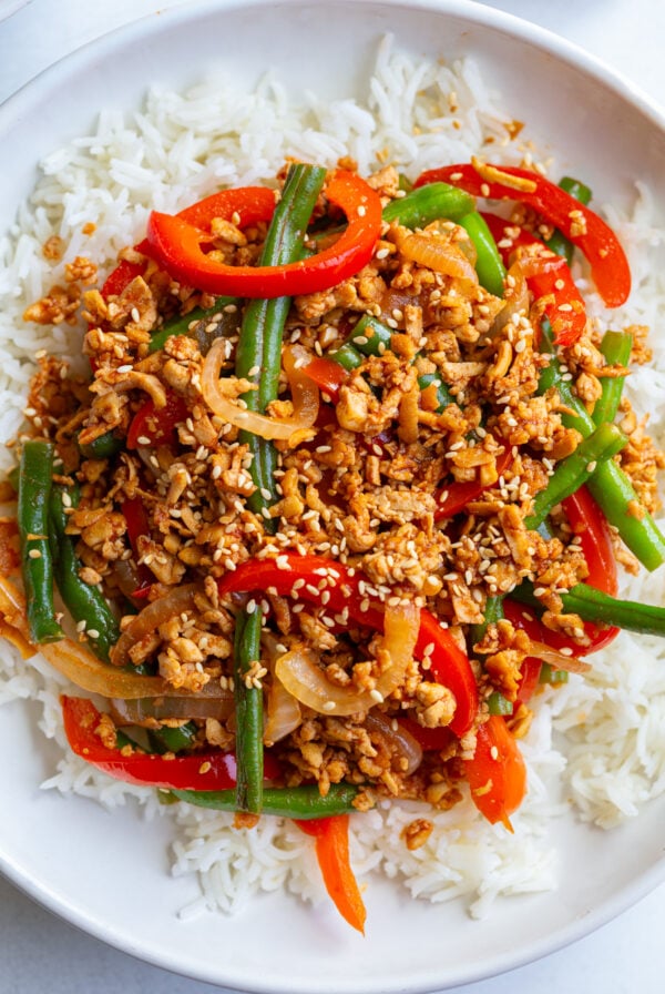 ground tofu stir fry with red bell pepper and green beans on a bed of white rice