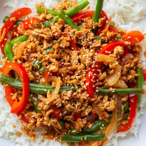 ground tofu stir fry with red bell pepper and green beans on a bed of white rice