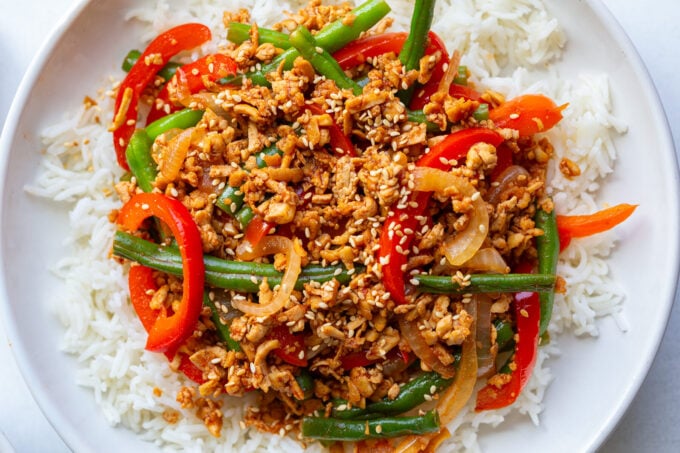 ground tofu stir fry with red bell pepper and green beans on a bed of white rice