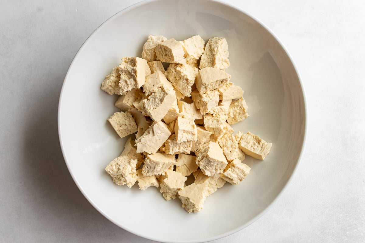 torn pieces of raw tofu in a large bowl