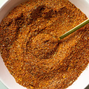homemade fajita seasoning in a small bow with a gold spoon dipped in it