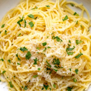 garlic butter noodles on a plate topped with parmesan and chopped parsely
