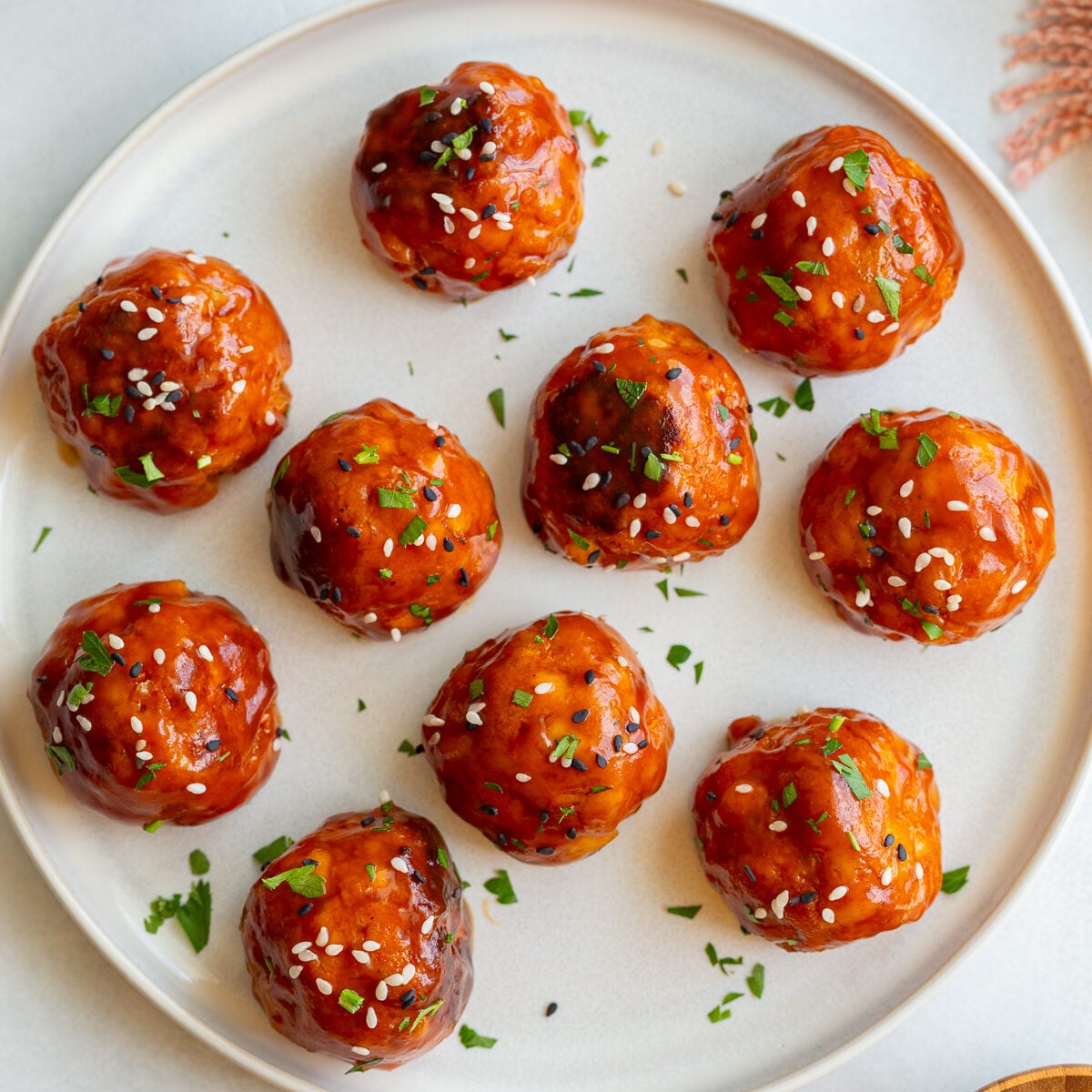 tofu meatballs covered in a sticky sauce and sesame seeds