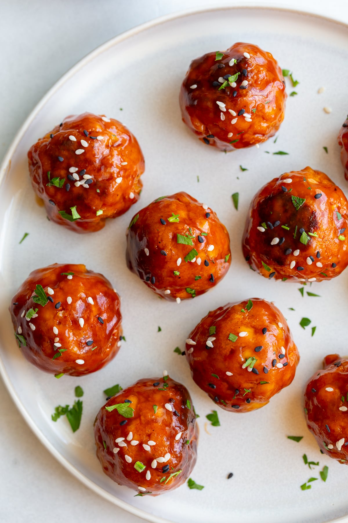 tofu meatballs covered in a sticky sauce and sesame seeds