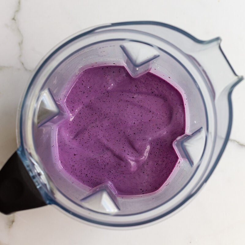 Overhead shot of a smooth, thick purple blueberry banana smoothie in a blender