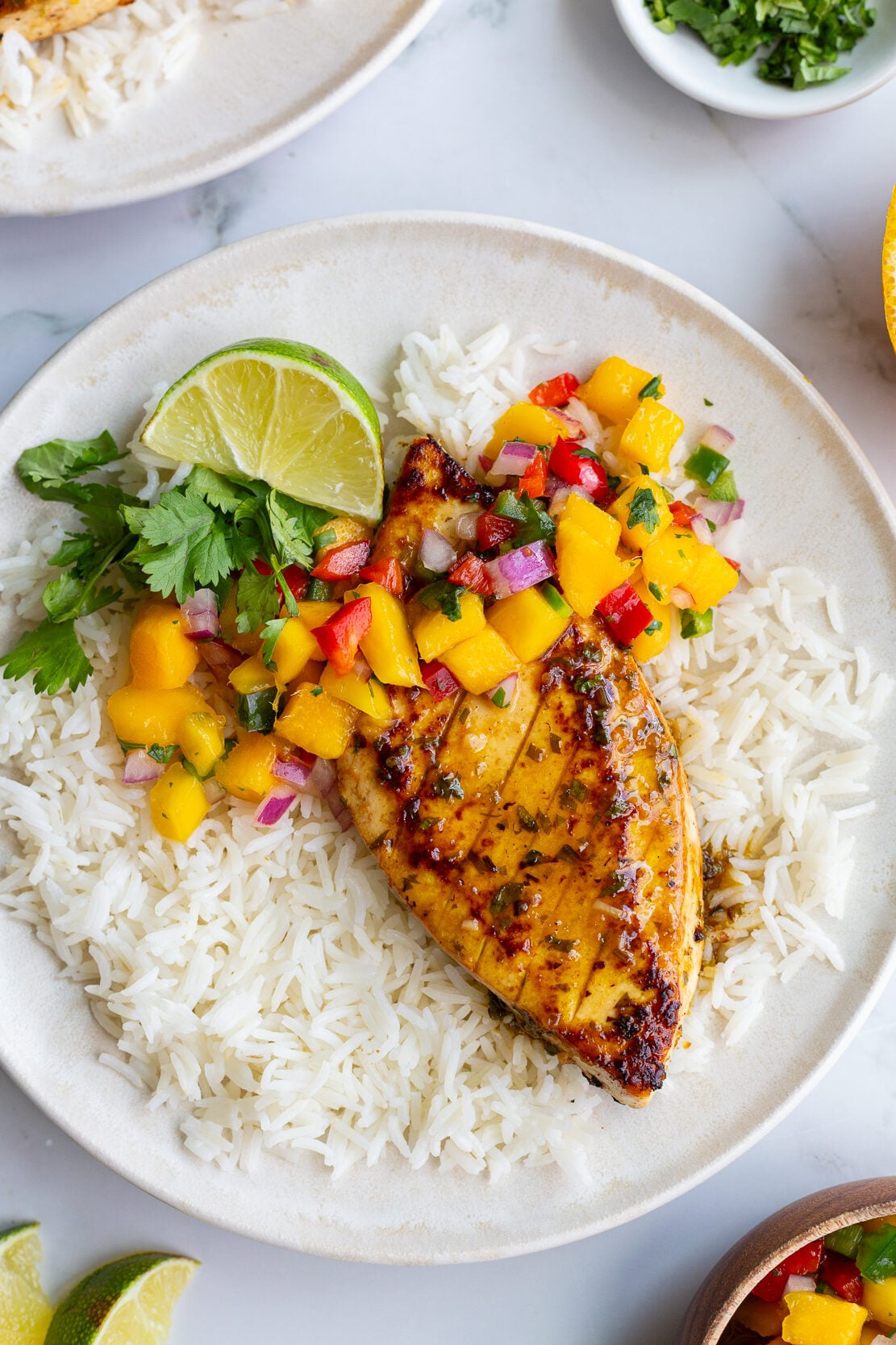 cilantro lime tofu that looks like grilled chicken with a mango salsa on top. all on a bed of rice