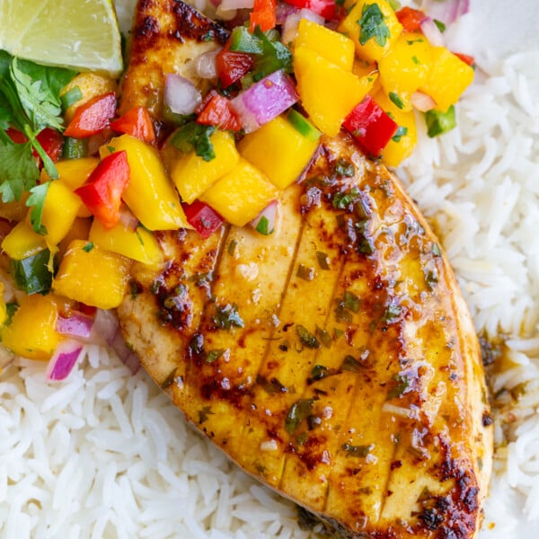 cilantro lime tofu that looks like grilled chicken with a mango salsa on top. all on a bed of rice
