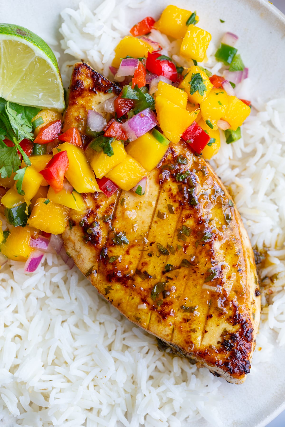 cilantro lime tofu that looks like grilled chicken with a mango salsa on top. all on a bed of rice