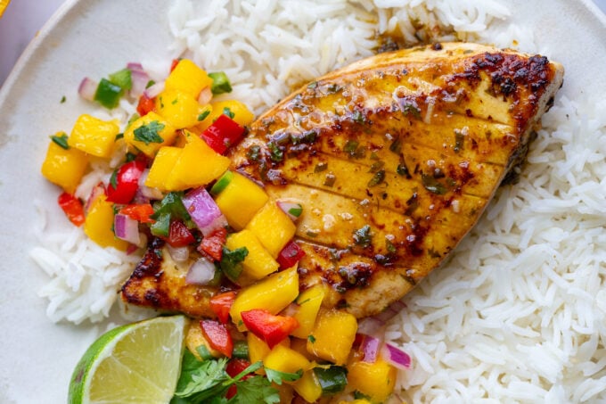 cilantro lime tofu that looks like grilled chicken with a mango salsa on top. all on a bed of rice