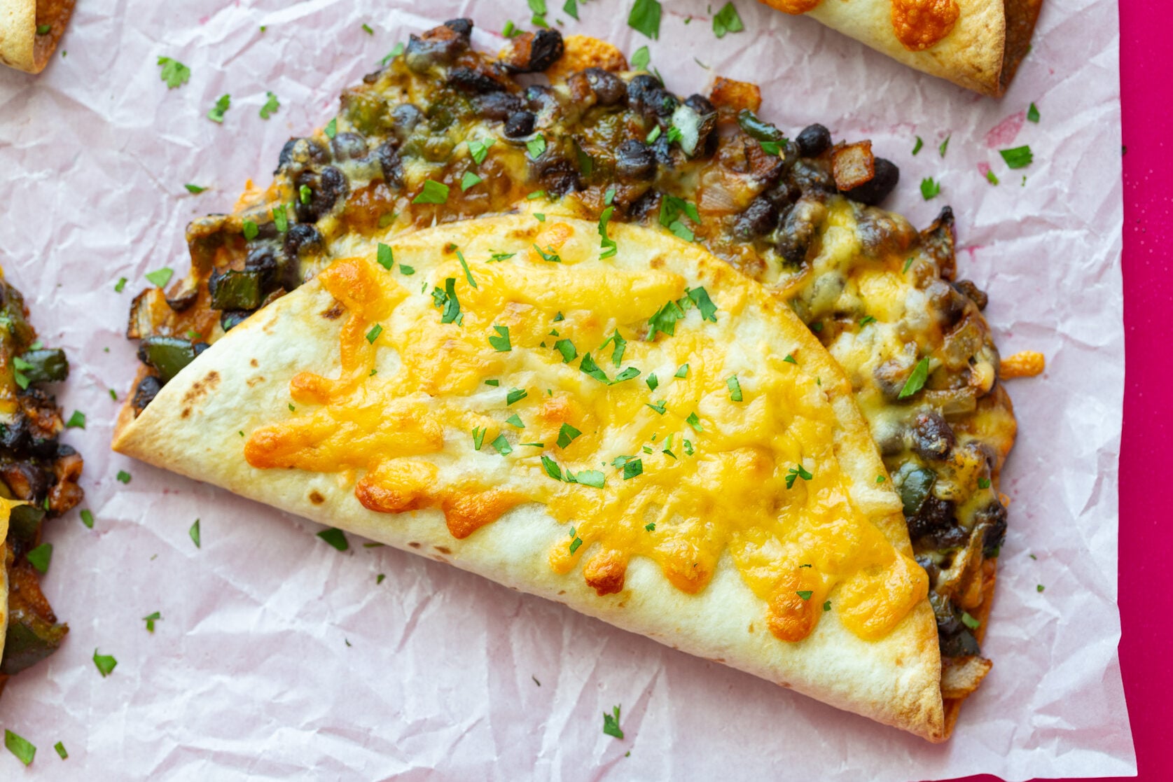 crispy black bean tacos with melted cheese on the outside. sprinkled with cilantro