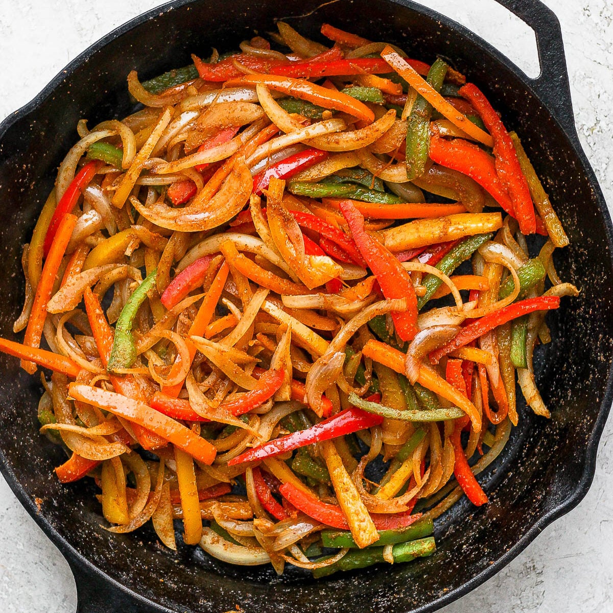 Sautéed bell peppers and onion in a cast iron skillet.