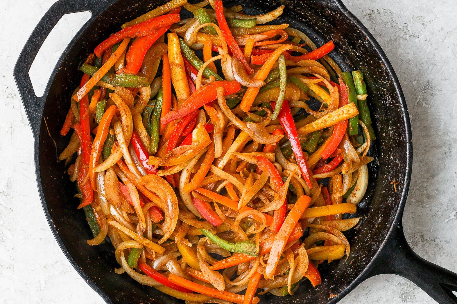 Sautéed bell peppers and onion in a cast iron skillet.