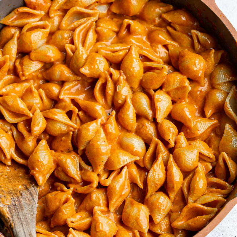 Pasta shells tossed in creamy vodka sauce in a skillet, ready to serve.
