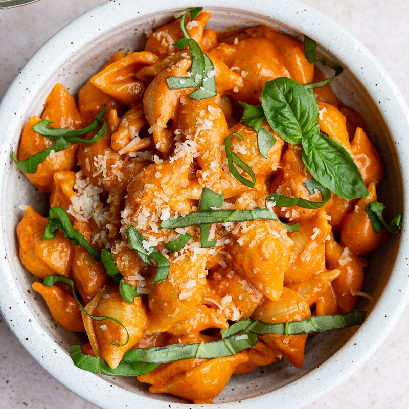 Pasta shells with sauce and topped with fresh basil.