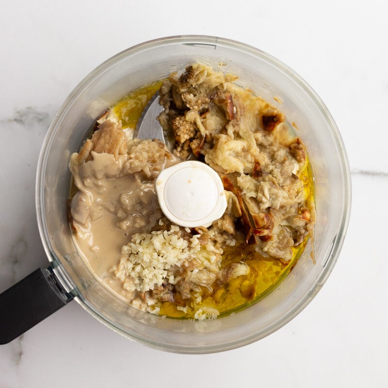 roasted eggplant, tahini, garlic and olive oil in a food processor bowl before blending