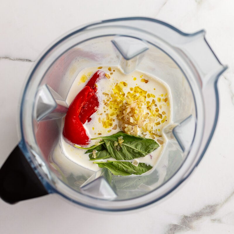 Roasted red pepper, cream, basil, and garlic in a blender before blending into pasta sauce