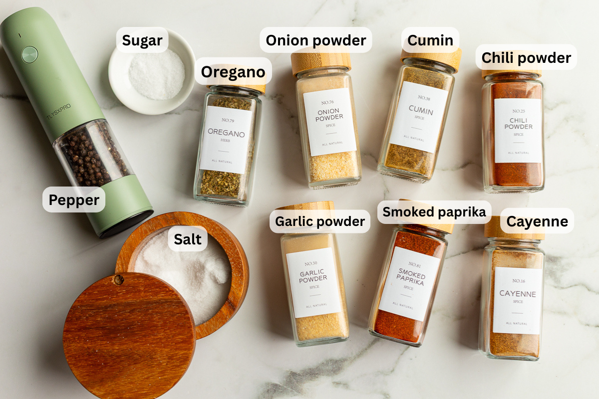 ingredients need to make fajita seasoning laid out on a flat surface so you can see the names of the spices including smoked paprika, chili powder, onion powder, garlic powder, salt and pepper