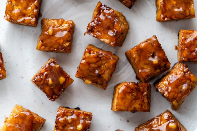 close up shot of baked tempeh covered in a teriyaki sauce