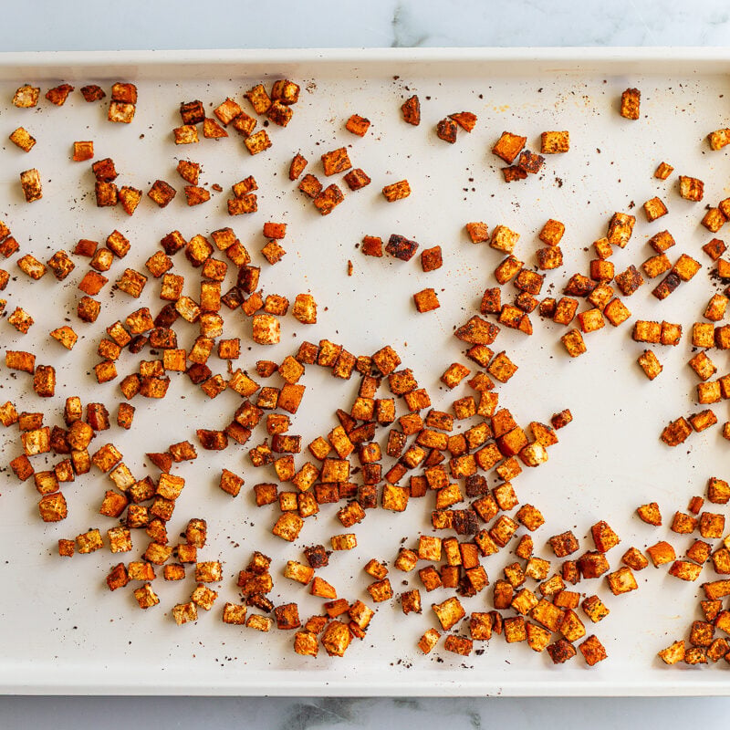 roasted sweet potato on a white sheet pan