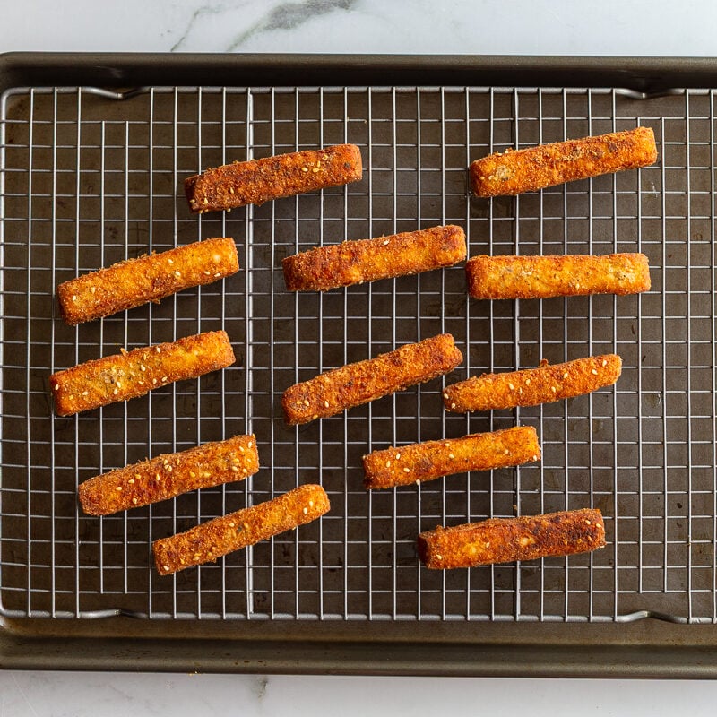 halloumi fries on a wire rack cooling after being fried