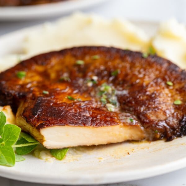 Close-up of a sliced lion's mane steak showing its dense, meaty white interior, served over mashed potatoes