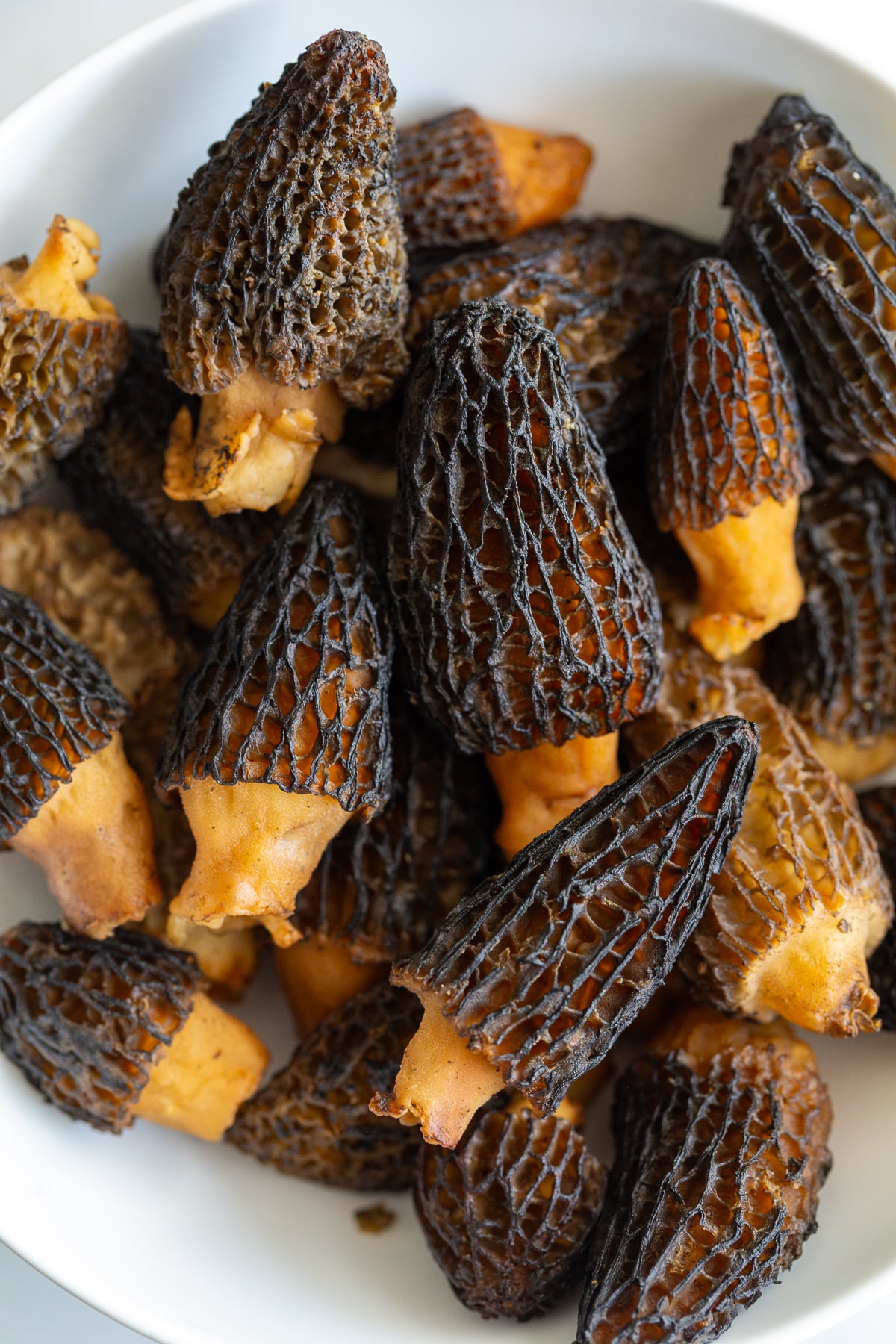raw morel mushrooms stacked in a bowl