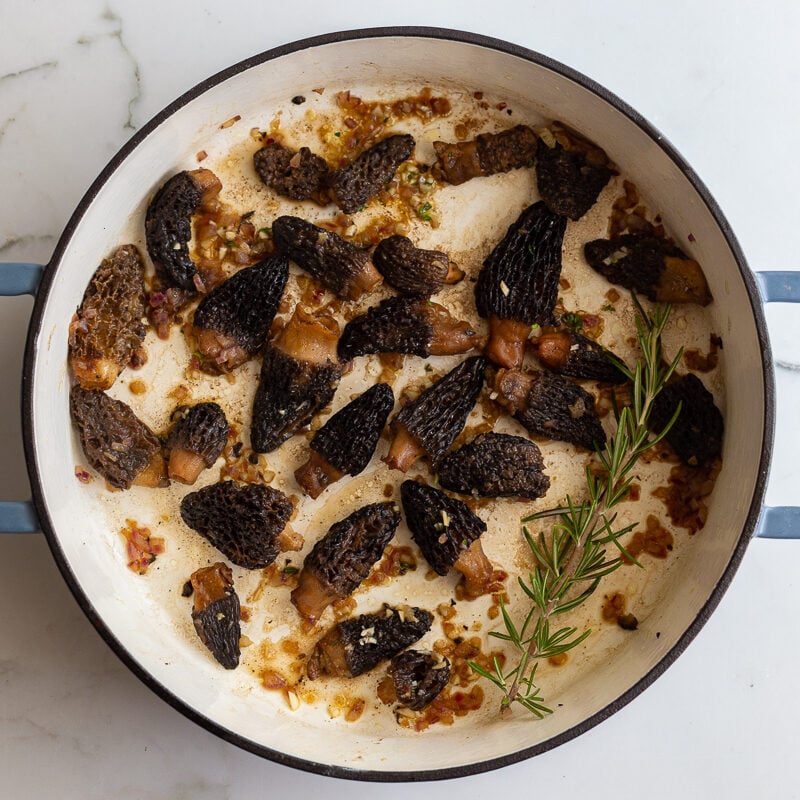 more mushrooms sauteed in a skillet with shallot, garlic, and fresh herbs