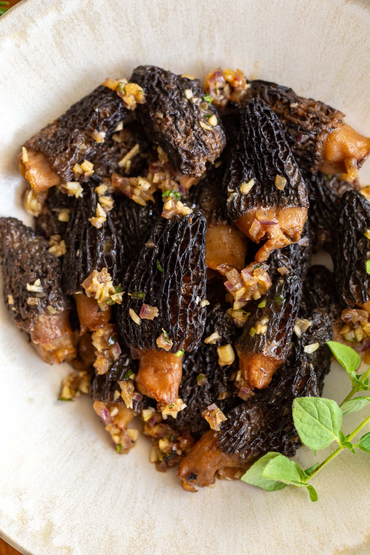 sauteed morel mushrooms in a bowl and topped with oregano