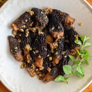 sauteed morel mushrooms in a bowl and topped with oregano