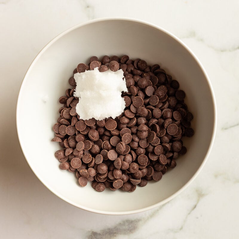 chocolate chips and coconut oil in a white bowl before being melted