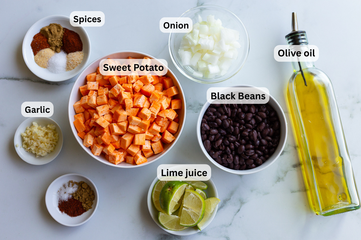 labeled ingredients needed to make sweet potato and black bean tacos including sweet potato, black beans, onion, lime, spices, and olive oil