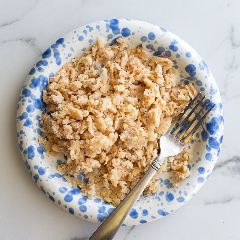 white beans mashed on a blue and white plate
