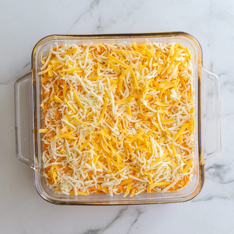 buffalo bean dip topped with cheese before it's baked