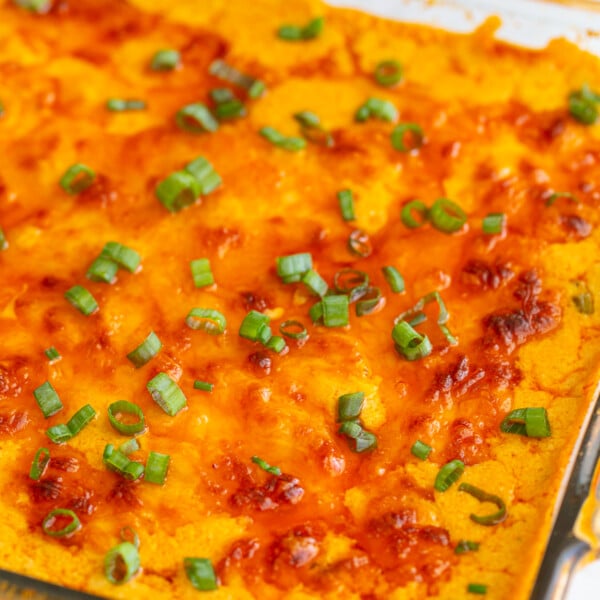 vegetarian buffalo dip in a glass baking dish with a golden cheesy topping