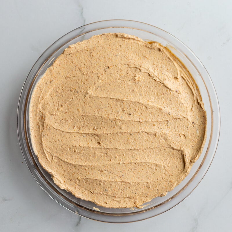 cream cheese smeared in the bottom of a pie dish