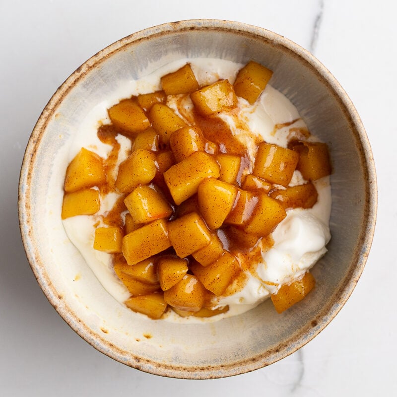 soft cinnamon apples on top of vanilla ice cream