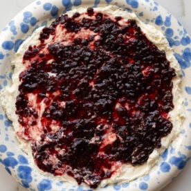 cream cheese and pepper jelly dip on a blue and white speckled plate