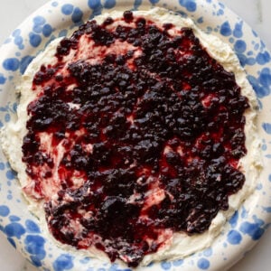 cream cheese and pepper jelly dip on a blue and white speckled plate