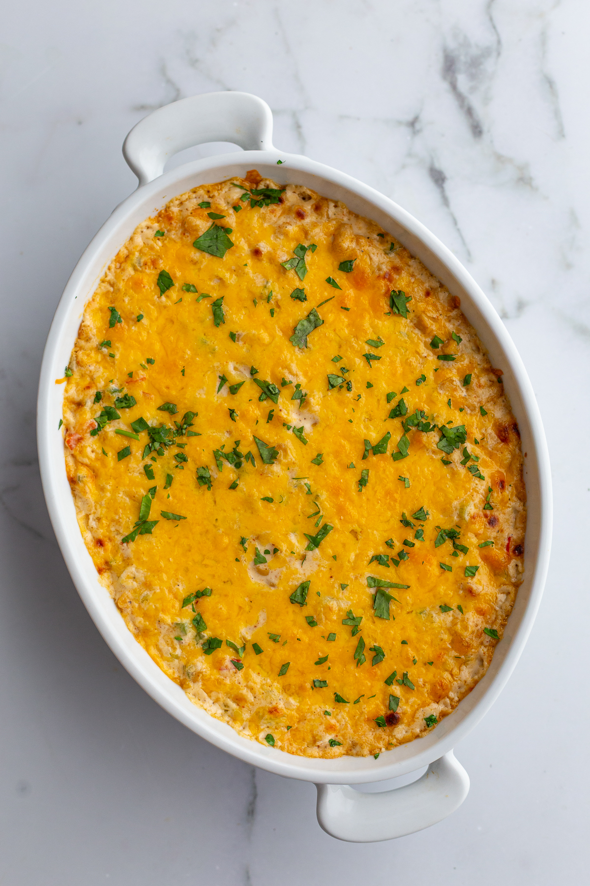 cream cheese corn dip in an oval dish