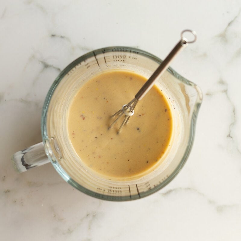 maple dijon dressing whisked in a measuring cup