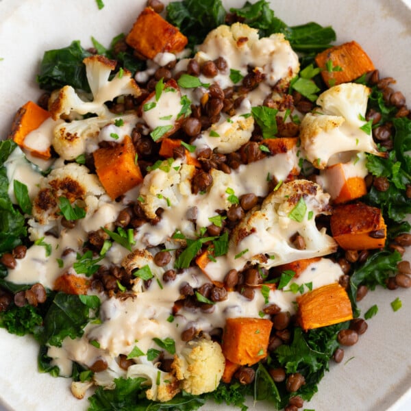 Roasted Sweet Potato lentil bowls in a large bowl drizzled with a dijon dressing