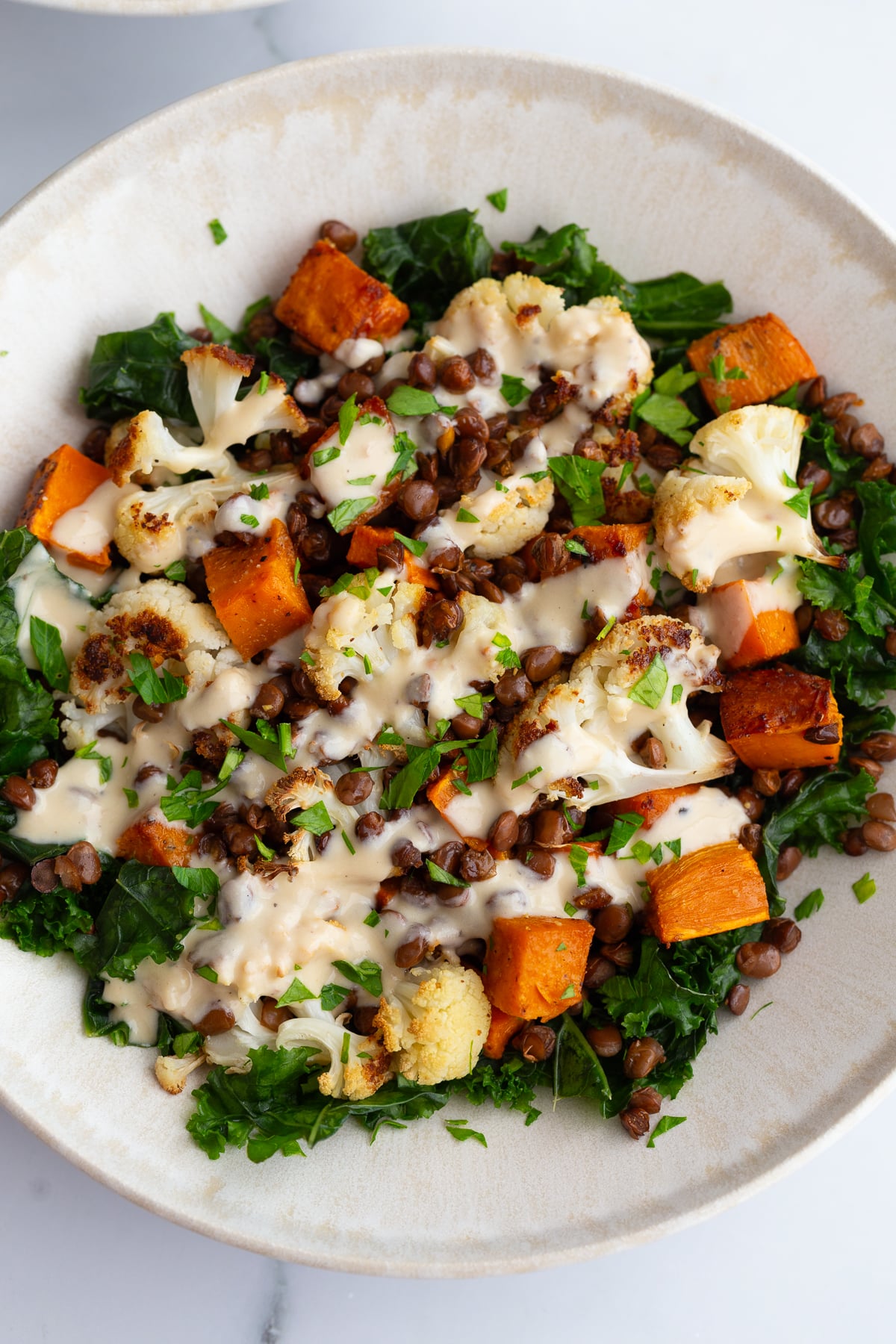 Roasted Sweet Potato lentil bowls in a large bowl drizzled with a dijon dressing